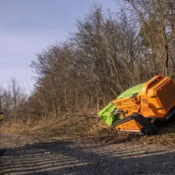 GreenClimber pri práci na svahu, kde odstraňuje náletové dreviny a prerastenú vegetáciu popri ceste.